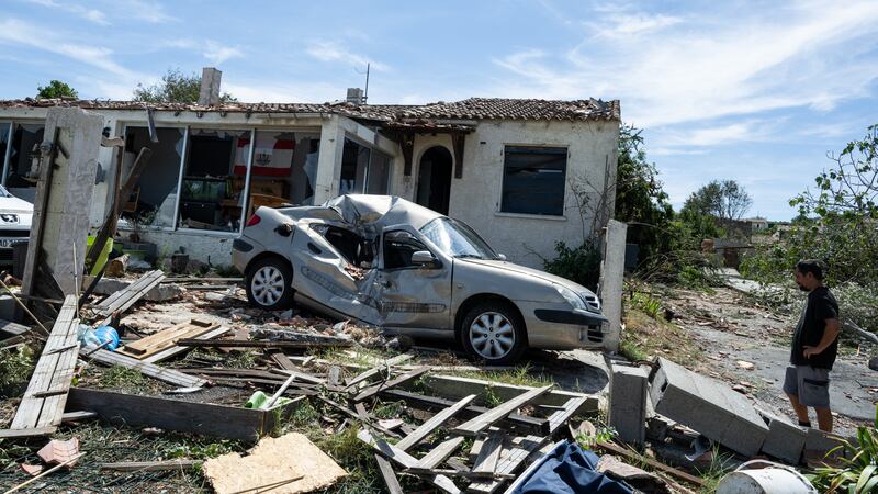 A resident watches a damaged house after a tornado ravaged the small village of Pomas in...