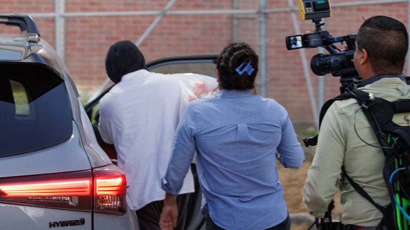 El agente de inmigración Christian Castro sube a un coche rodeado de periodistas momentos...