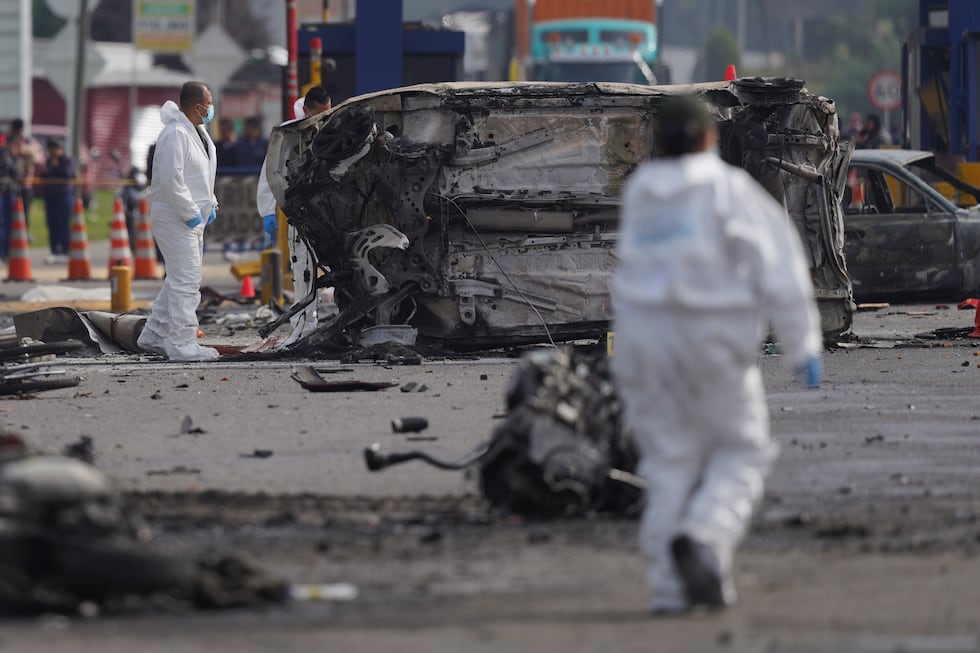 Los forenses trabajan en el lugar de un accidente mortal en el que se vieron implicados varios...