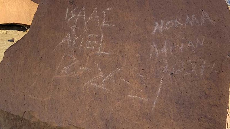 Nombres y fecha tallados en una antigua roca en Big Bend.
