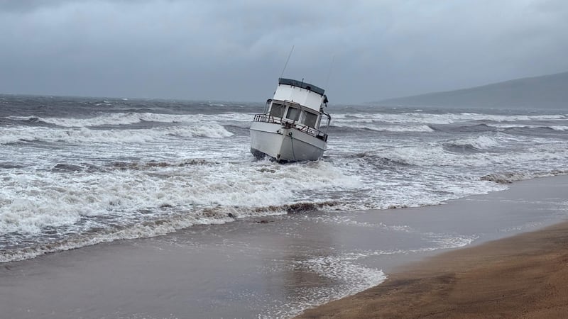 En esta foto proporcionada por el condado Maui, un barco está encallado en una playa frente a...
