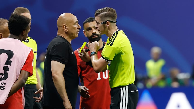 El técnico de Egipto Hossam Hassan es amonestado por el árbitro francés Francois Letexier...