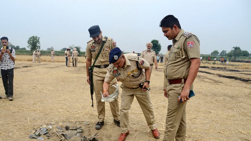 Efectivos de la policía india inspeccionan un objeto que se cree que formaría parte de un...
